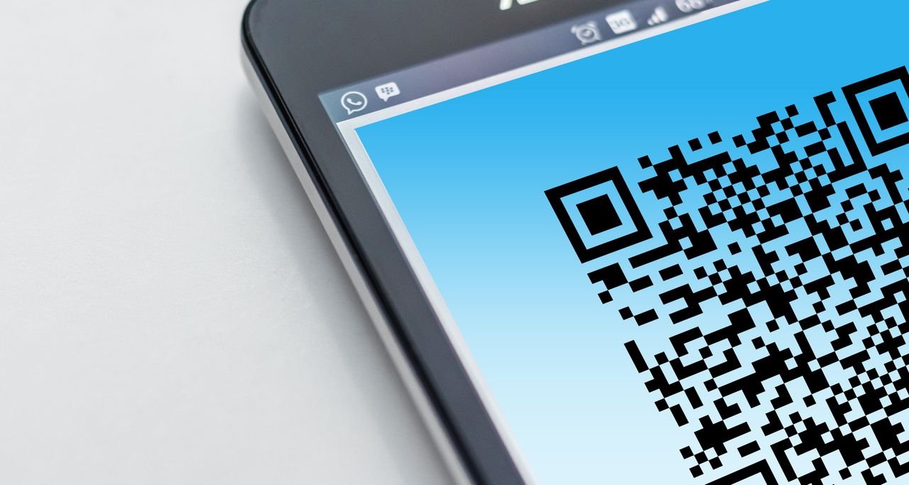 heros-img High-resolution close-up of a smartphone displaying a QR code on its screen.