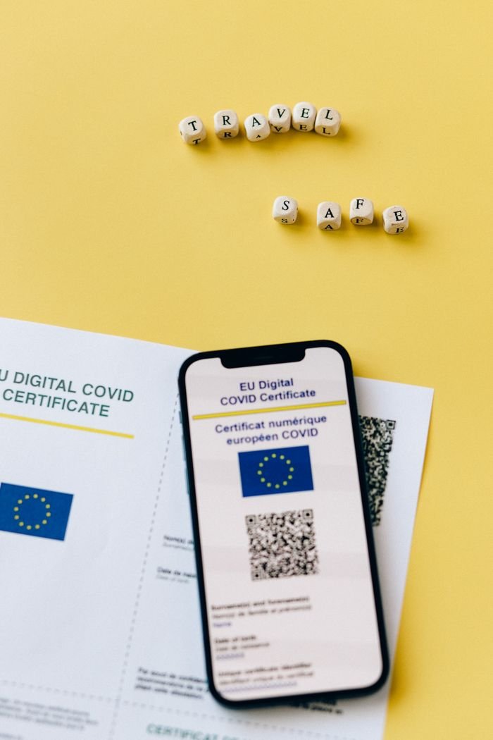 services-03 EU Digital COVID certificate with phone on yellow backdrop symbolizes travel safety.